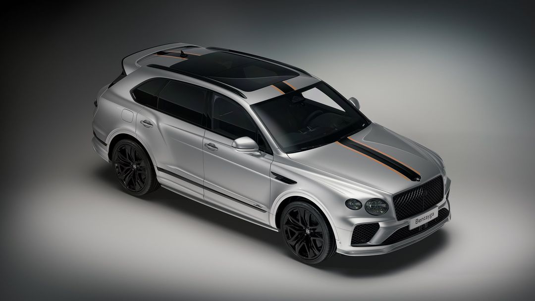Bentley Bentayga Mulliner — przód 3/4 z góry, srebrny lakier z pomarańczowym pasem, czarne felgi