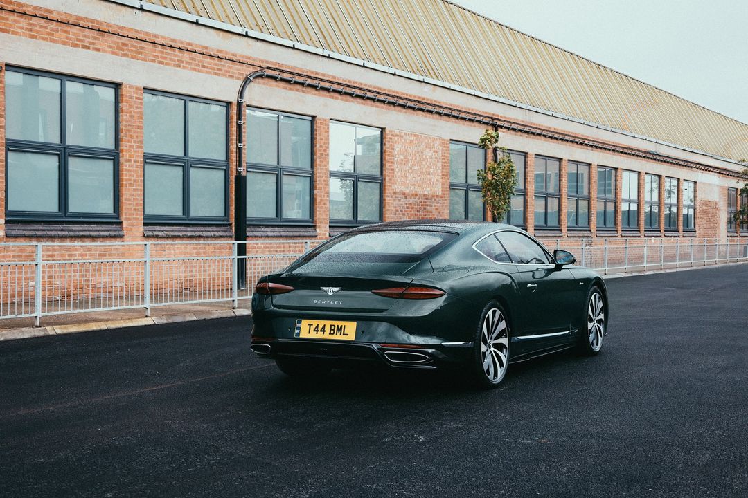 Bentley Continental GT Azure - tył, widok 3/4 na tle fabrycznej hali w Crewe