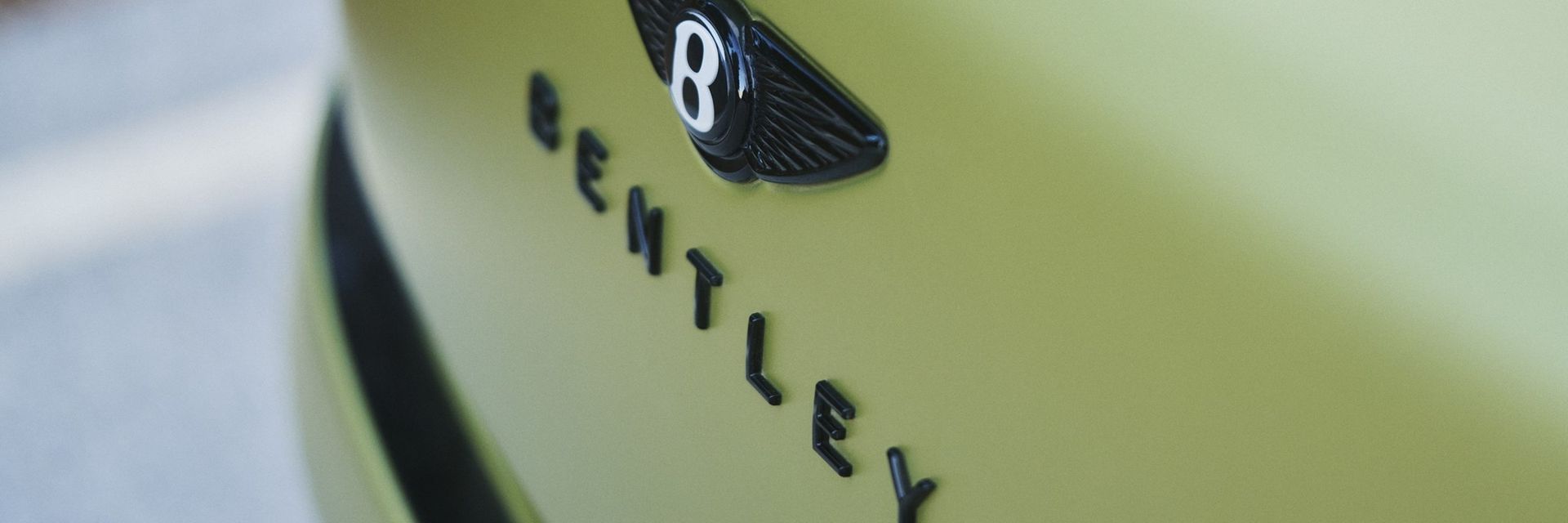 Bentley — detal: emblemat marki na masce, zbliżenie