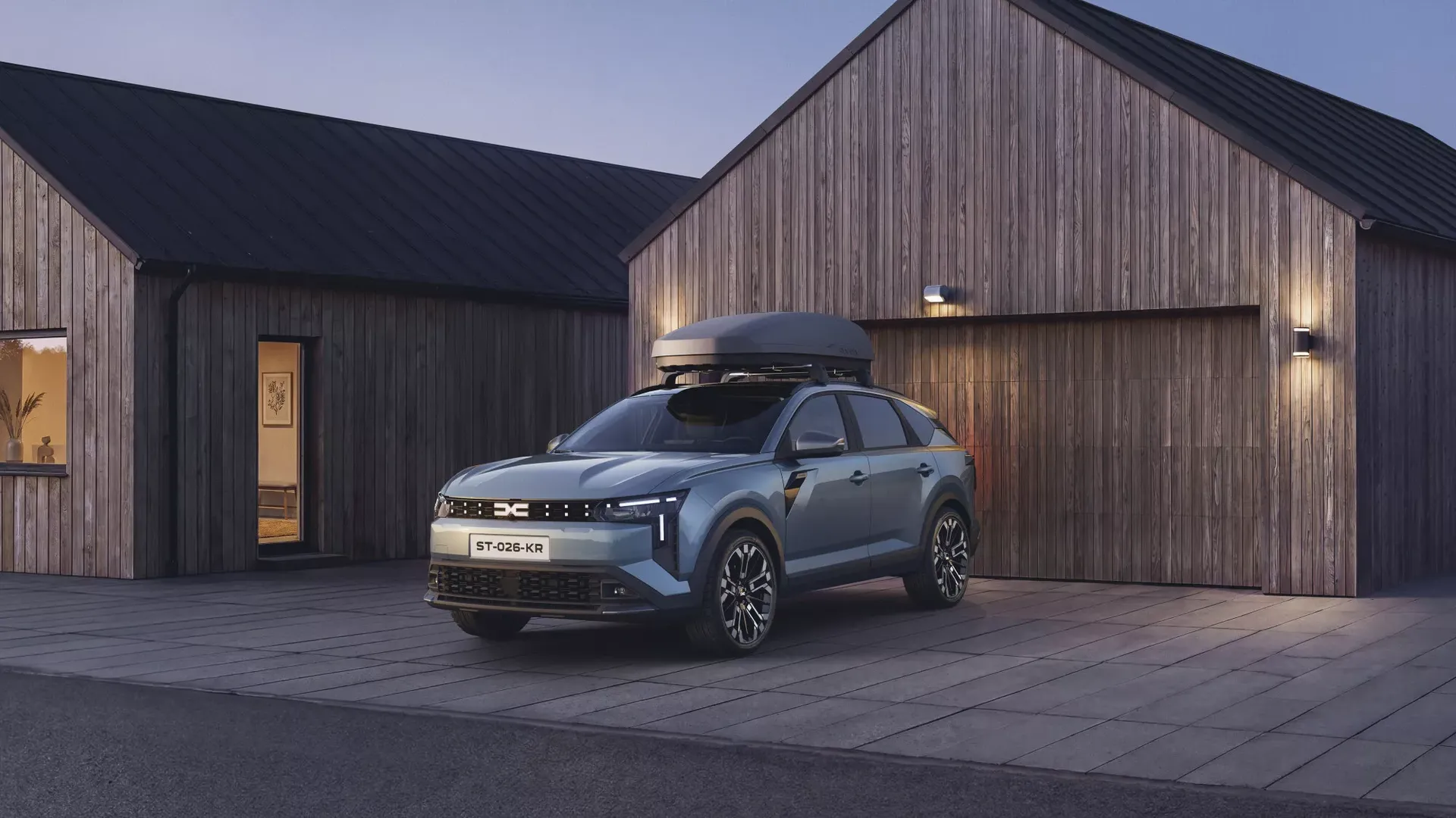 Dacia Striker — przód, postój z boksem dachowym przed drewnianym domem