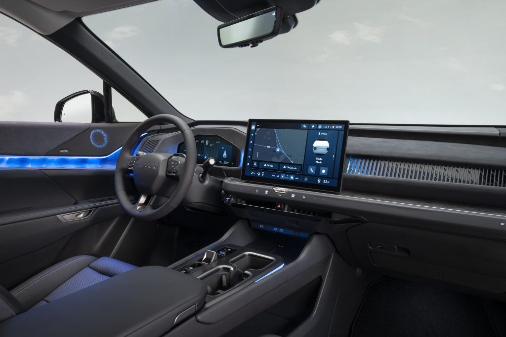 Lexus TZ — kokpit, kierownica po lewej (LHD), cyfrowe zegary i duży ekran multimedialny, niebieskie podświetlenie