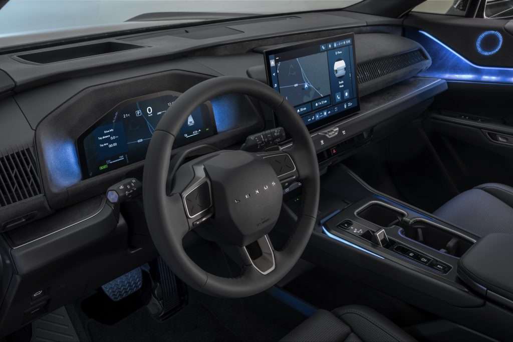 Lexus TZ — kokpit z bliska, kierownica z logo „LEXUS”, podwójny wyświetlacz cyfrowy, niebieskie podświetlenie ambientowe