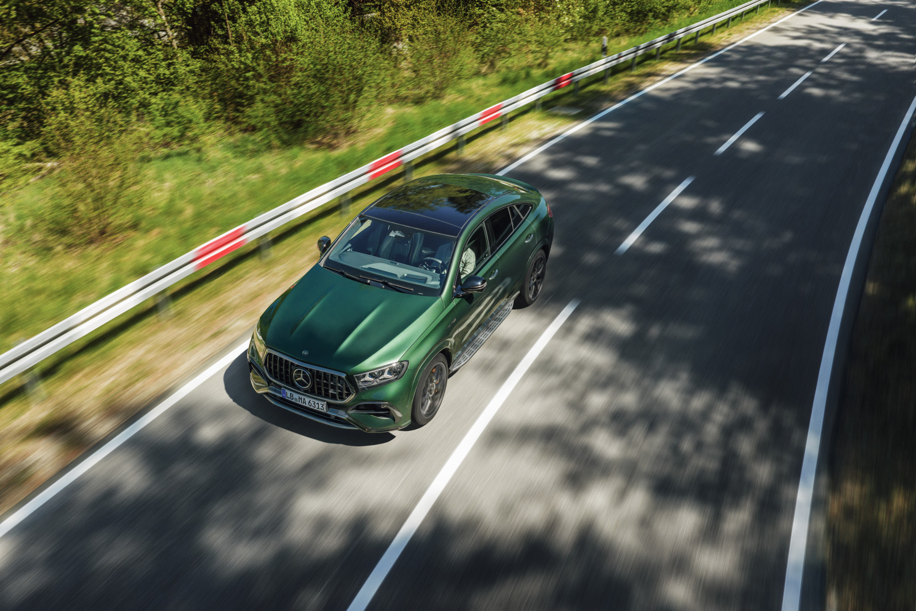 Mercedes-AMG GLE 63 S Coupe — przód 3/4 z lotu ptaka, jazda drogą wśród zieleni