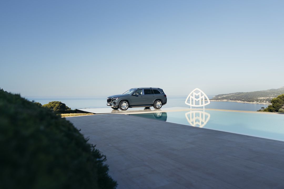 Mercedes-Maybach GLS — widok z boku na tarasie przy basenie, w tle morze; na zdjęciu duże logo Maybach