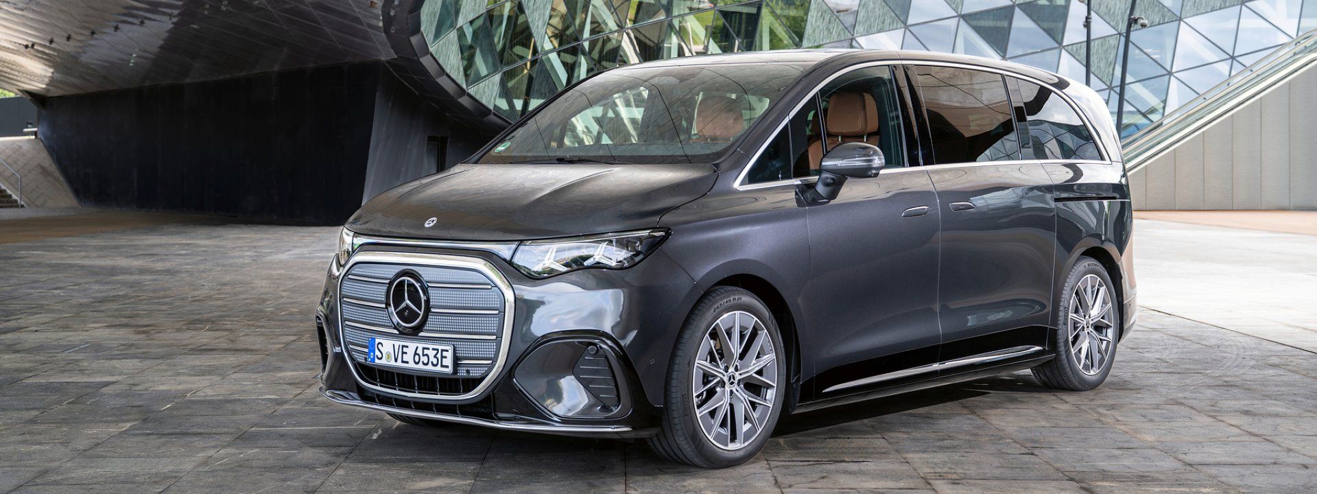 Mercedes VLE — przód i bok, ujęcie 3/4 na tle nowoczesnej architektury