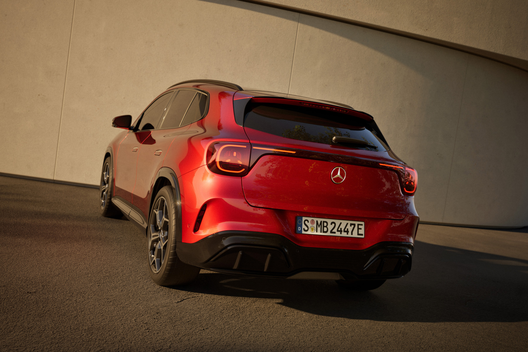 Mercedes-Benz GLA — czerwony, tył 3/4, ostre kontrastowe światło przy ścianie