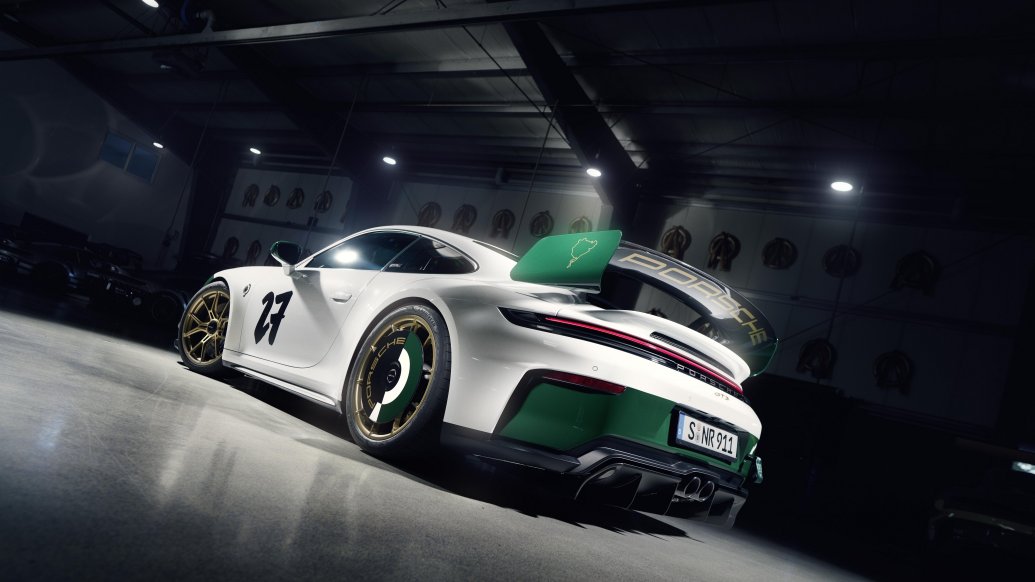 Porsche 911 GT3 — tył/3/4, statyczna prezentacja w mrocznym garażu z widocznym spoilerem