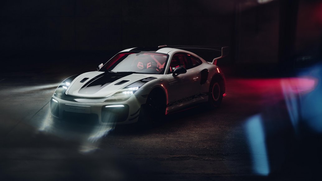 Porsche 911 GT2 RS Flachbau RS — dynamiczne ujęcie przodu w ciemnym garażu z czerwonym podświetleniem