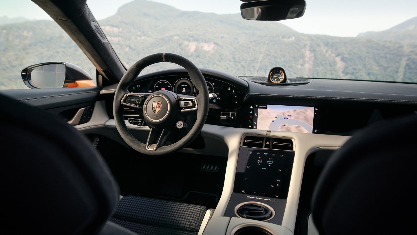 Porsche Taycan Turbo GT — wnętrze, kierownica i deska rozdzielcza (układ lewostronny), w tle góry