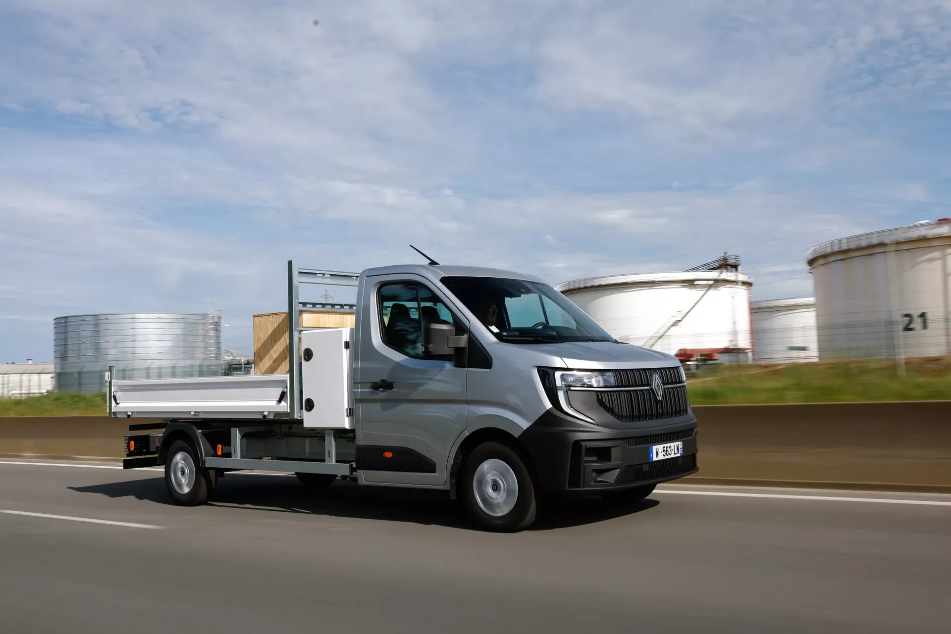 Renault Master (wersja skrzyniowa, kolor srebrny) — przód, jazda w otoczeniu przemysłowym