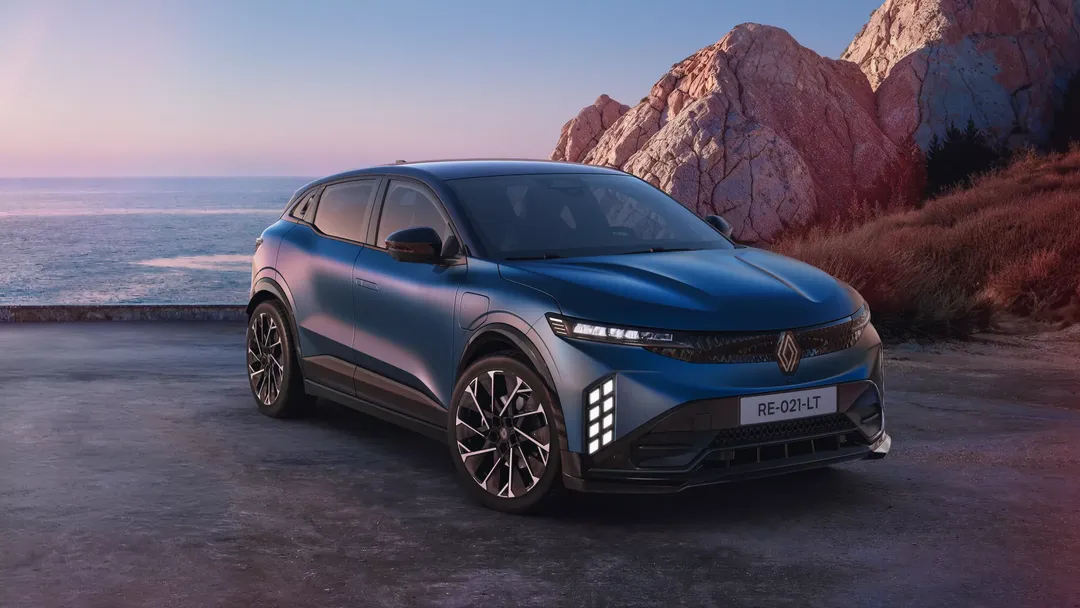 Renault Megane E-Tech Electric — przód/bok, zaparkowany na klifie nad morzem o zmierzchu