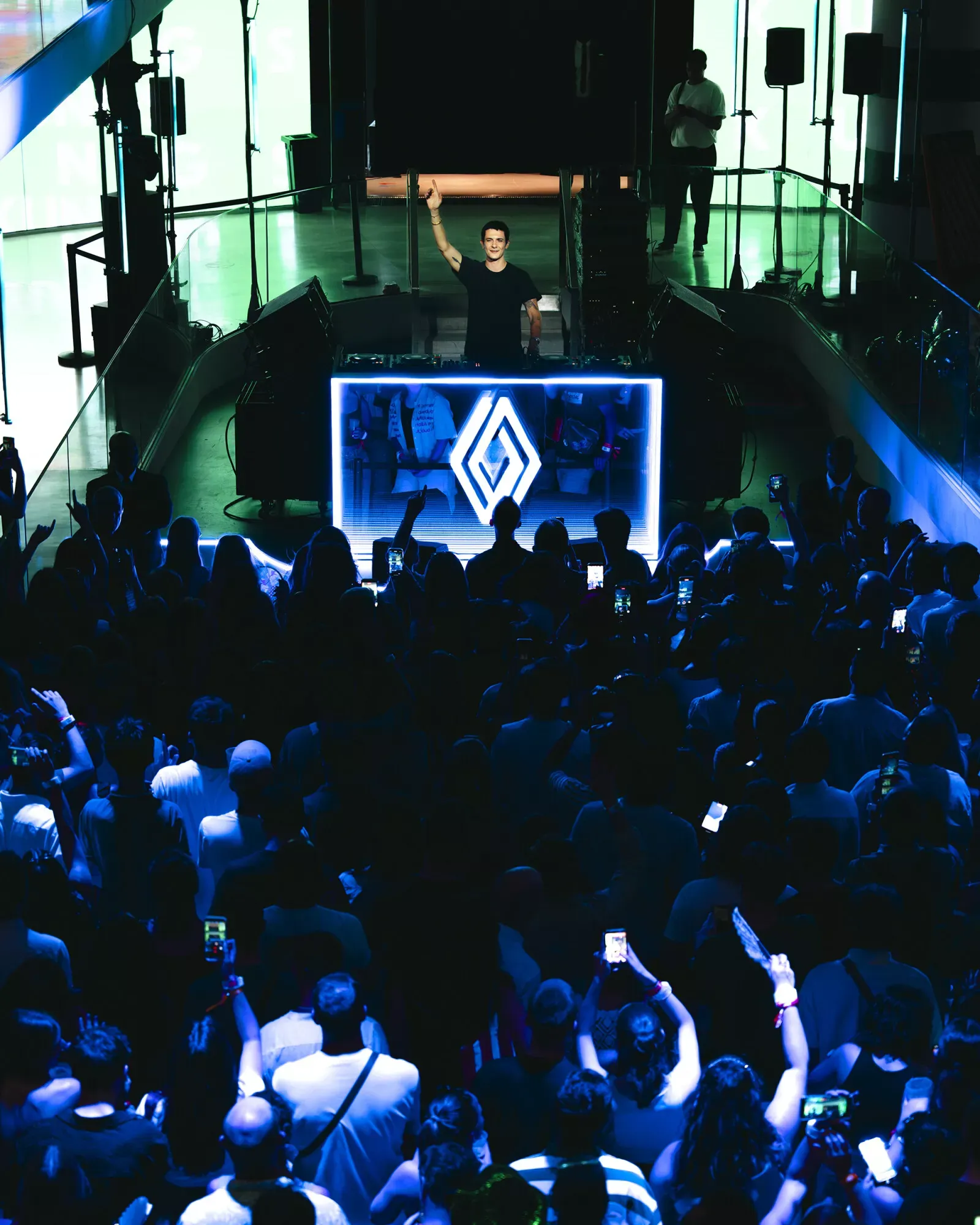Renault — nocna odsłona Twingo Live Show, DJ z uniesioną ręką i podświetlone logo marki, kadr pionowy
