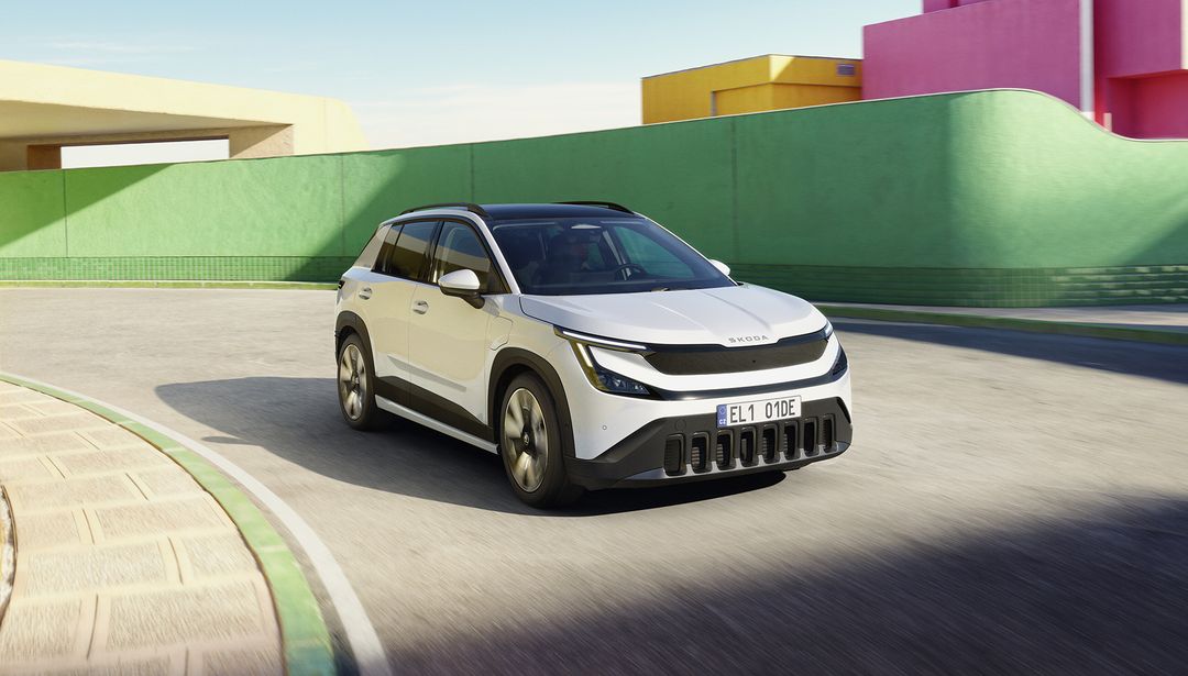 Škoda Epiq — dynamiczne ujęcie 3/4 przód podczas jazdy, kolorowe otoczenie miejskie