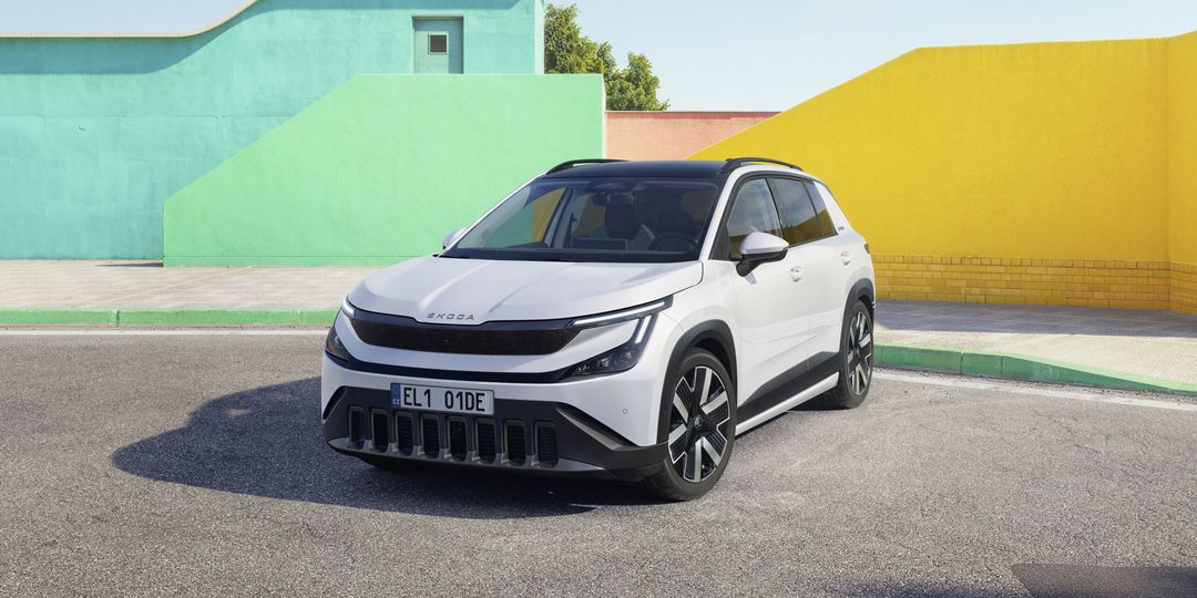 Škoda Epiq — przód 3/4, biały kolor, tło kolorowe ściany, oficjalna sesja prasowa