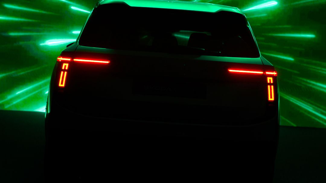 Škoda Peaq — teaser tylnej części, charakterystyczna sygnatura świetlna diodowych lamp w kształcie litery C na dramatycznym zielonym tle