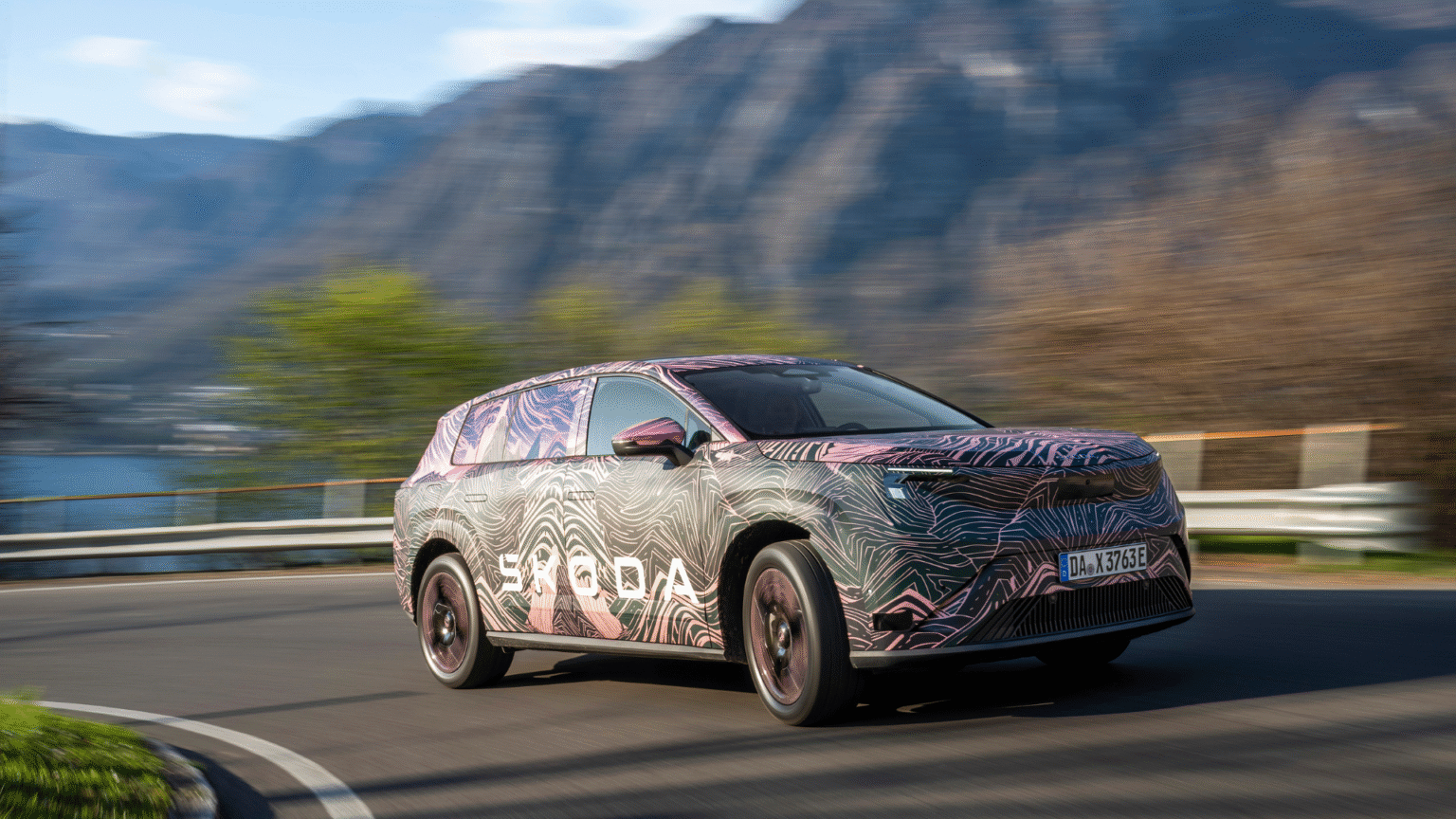 Škoda Peaq — ujęcie 3/4 z przodu lewego, jazda górską drogą, kamuflaż topograficzny, niemal identyczny kadr jak p01