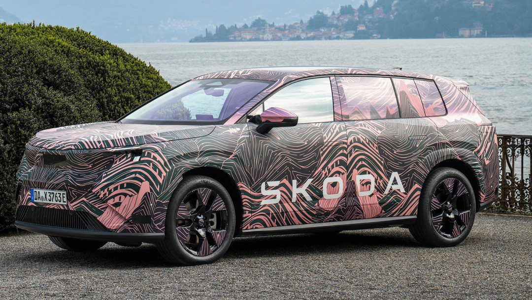 Škoda Peaq — ujęcie 3/4 z przodu lewego, postój nad jeziorem, miasteczko w tle, kamuflaż topograficzny