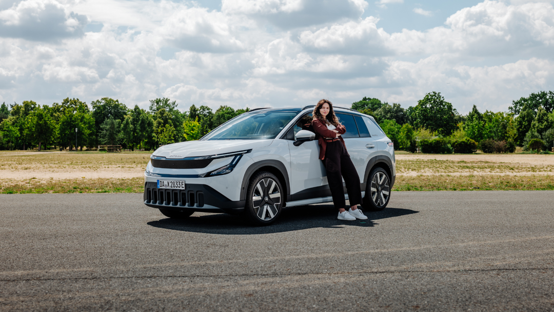 Škoda Epiq — przód, 3/4, auto z pasażerem na drodze