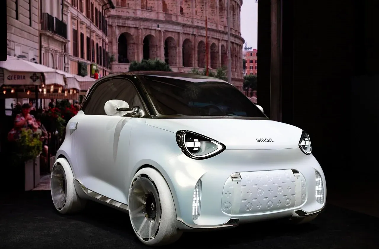 smart – przód, biały concept car na tle Koloseum w Rzymie